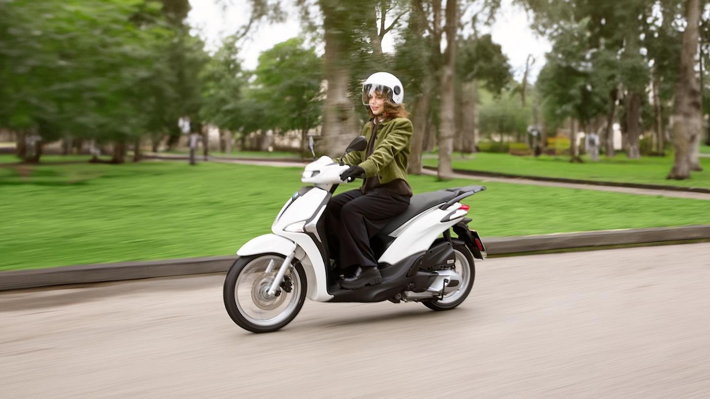 eine Frau auf einer weißen Piaggio Liberty 125 