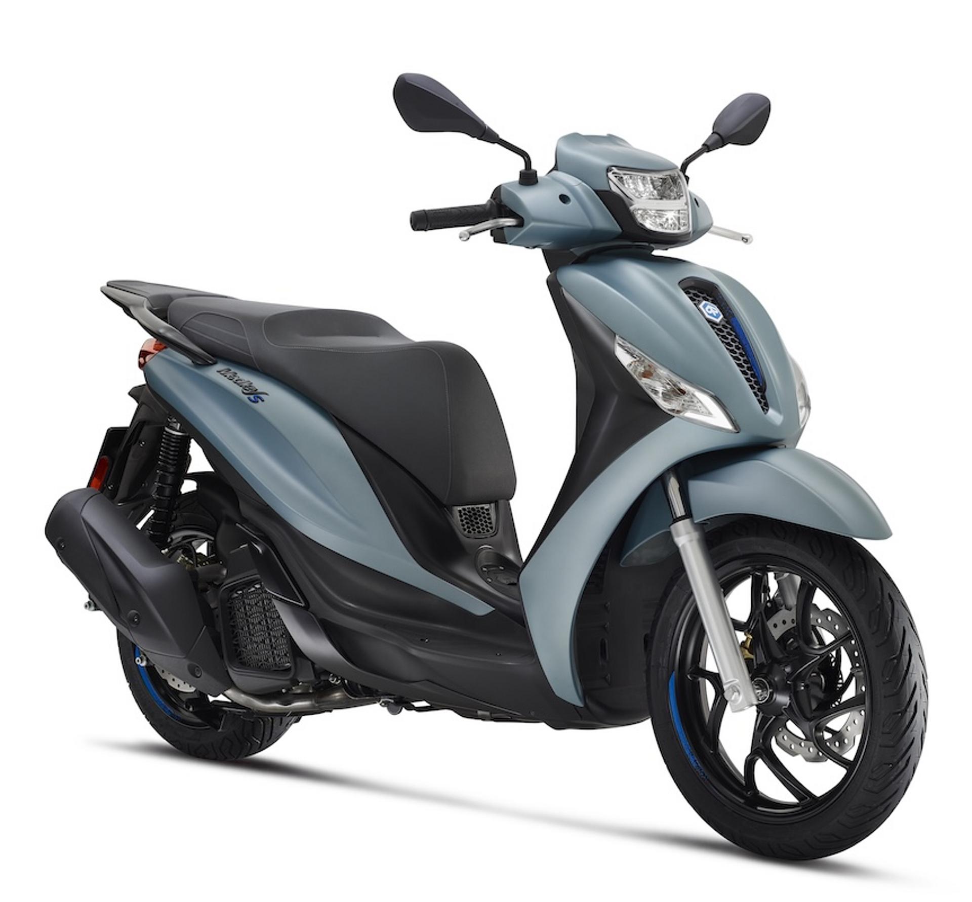 Piaggio Medley 125 in hellblau auf glänzendem Untergrund, Berge im Hintergrund