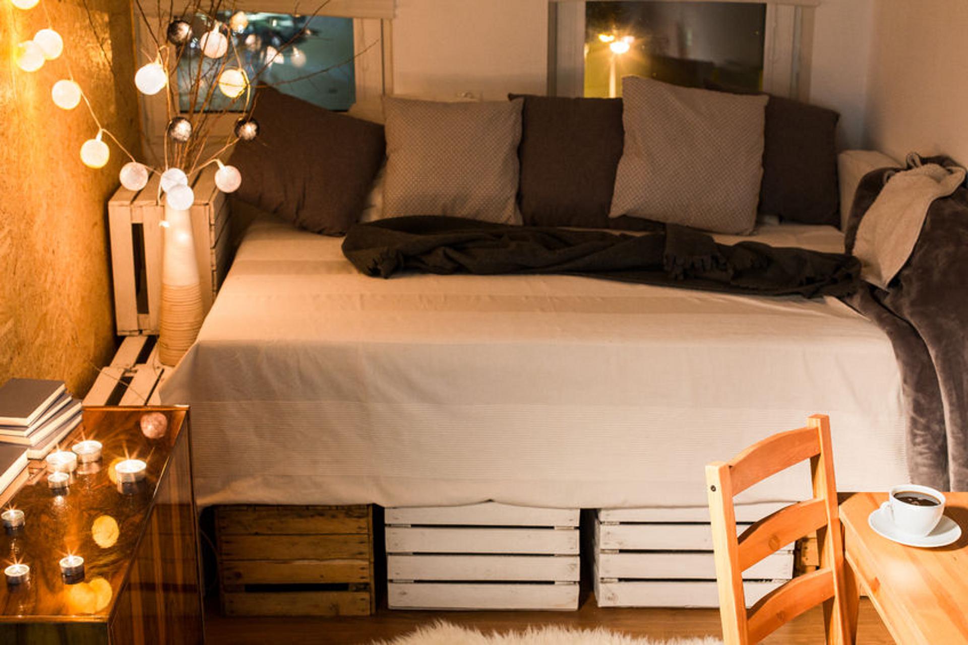 Bett in größerem Schlafzimmer mit viel Deko