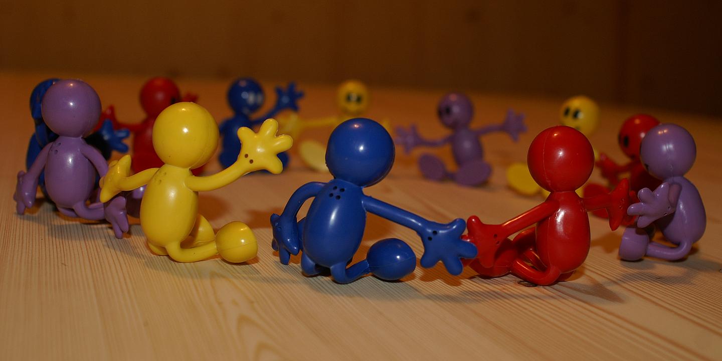 Selbsthilfegruppen Wien, Symbolbild: verschiedenfarbige Spielfiguren, die im Kreis sitzen