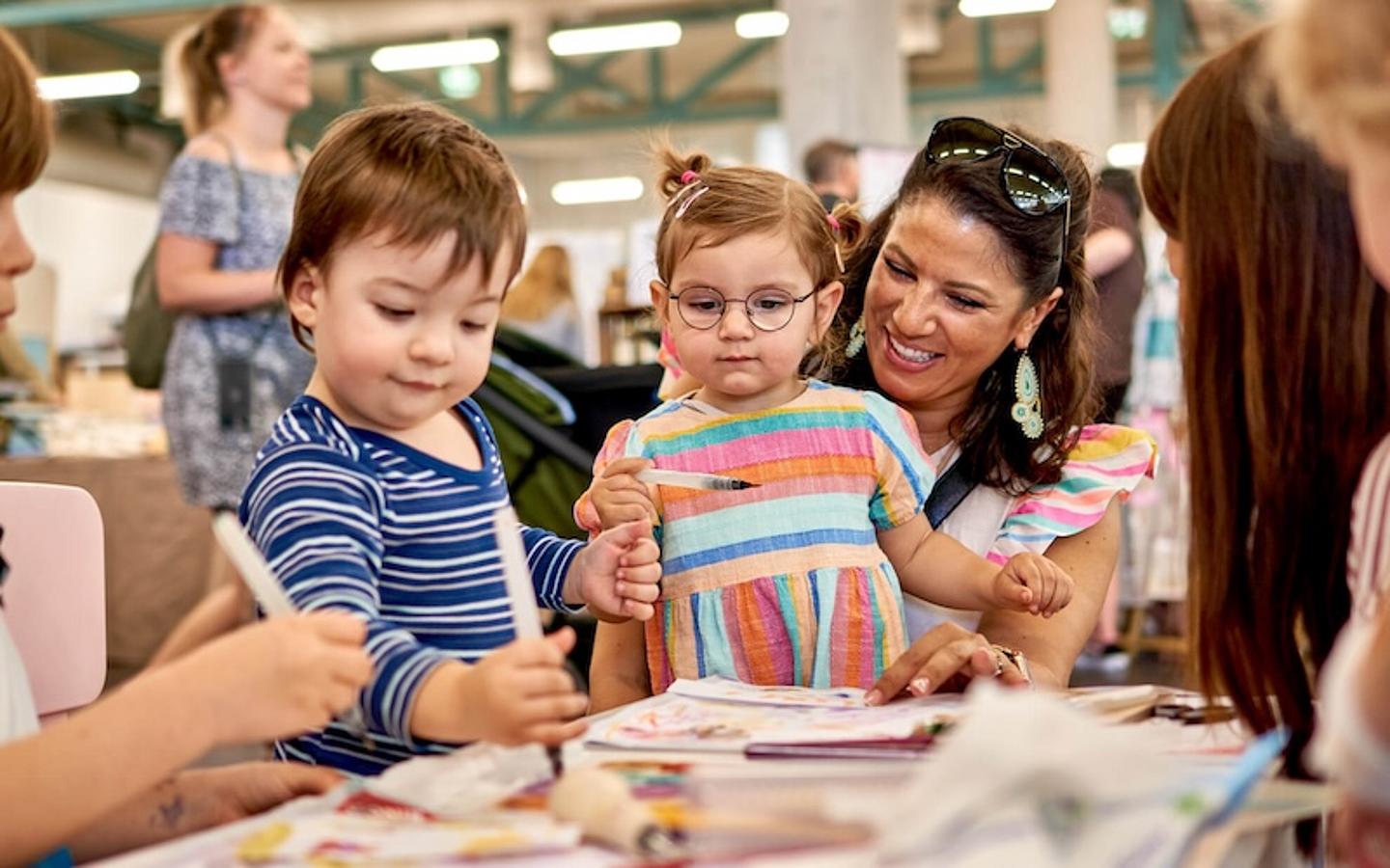 Mütter mit Kindern beim Basteln. 