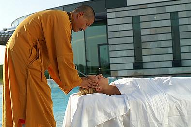 Ein asiatischer Masseur behandelt eine Kundin