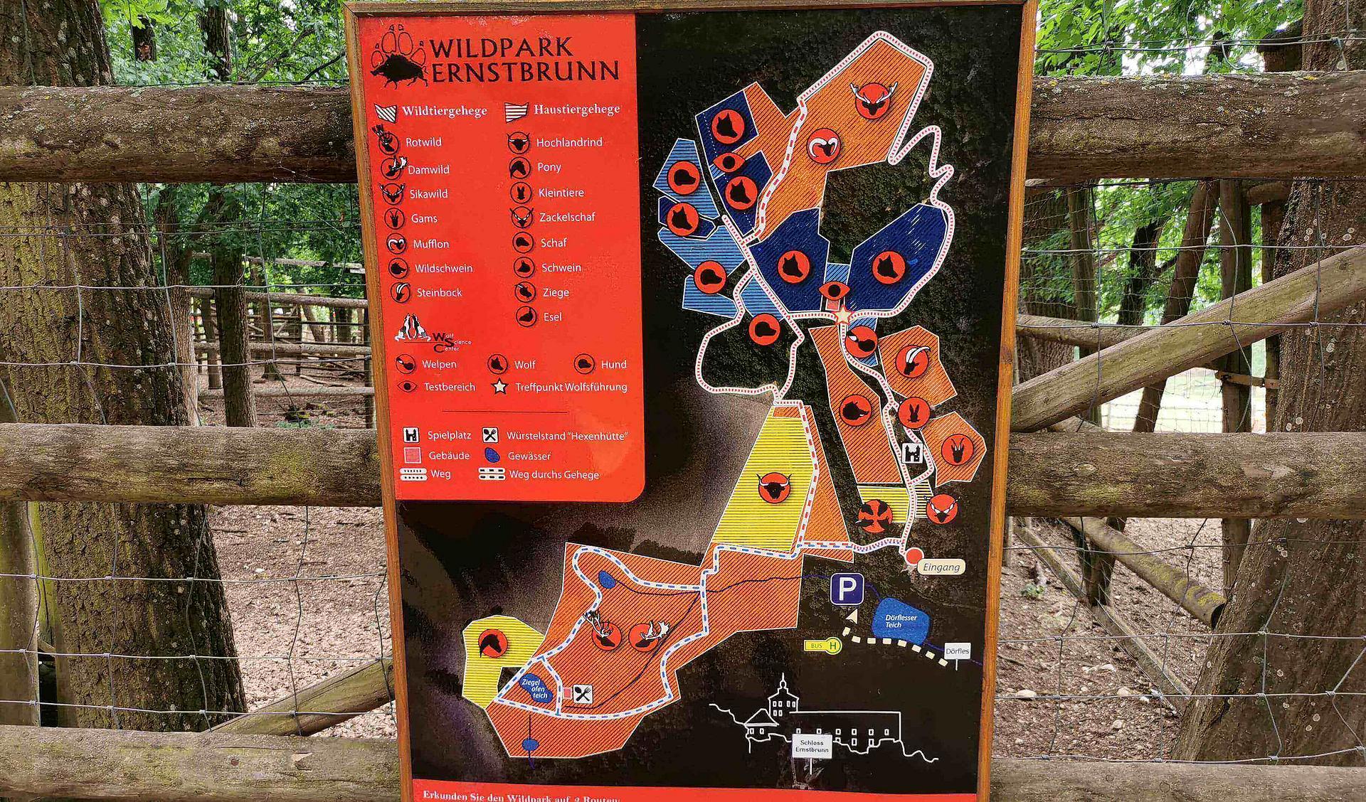 Der Plan des Wildparks hängt an einem Holzzaun