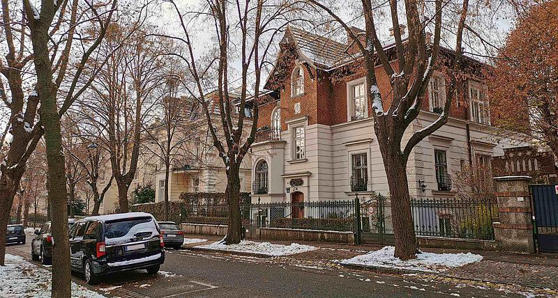 Eine zweistöckige Villa ist neben einer Straße