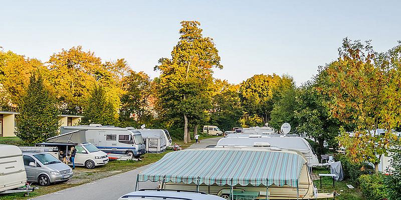 Stellplätze am Campingplatz Wien West Campingplatz, Wohnwägen, Autos, Zelte, Bungalows, Bäume, Weg