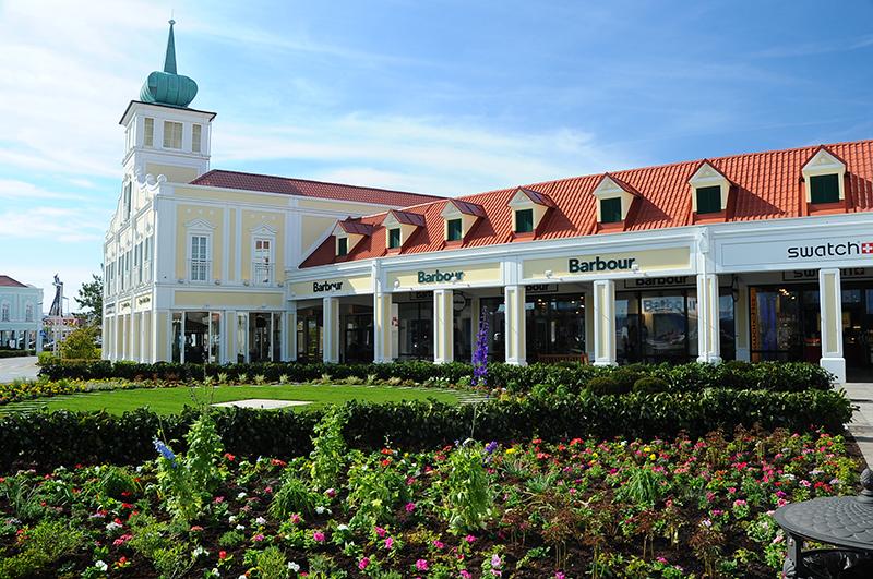 Blick über Grünflächen richtung Designer Outlet Parndorf