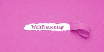 rosa Hintergrund aus Krepppapier darunter das Wort Weltfrauentag