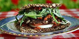 Veganes Brot mit Ruccula und Tomaten gefüllt auf einem Teller angerichtet