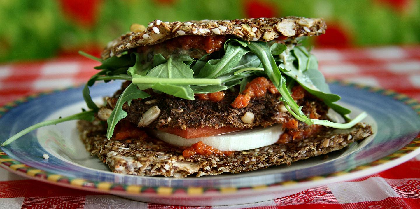 Veganes Brot mit Ruccula und Tomaten gefüllt auf einem Teller angerichtet