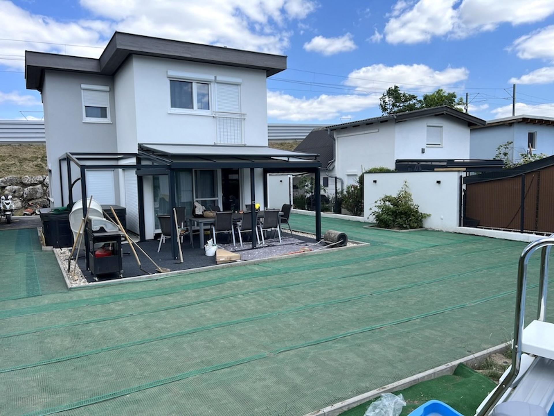 Garten mit Vlies ausgelegt und kleines Haus