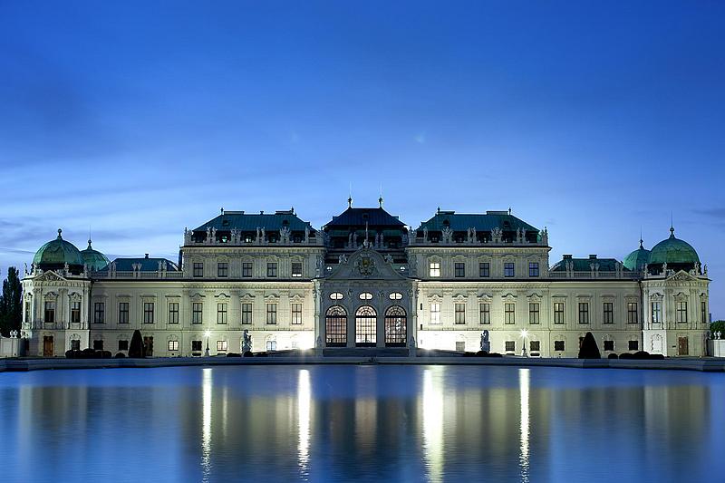 Das Schloss Belvedere spiegelt sich abends auf der Oberfläche des Teichs.