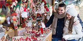 Pärchen kauft auf einem kleinen Design-Weihnachtsmarkt in Wien ein