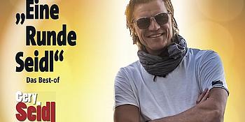Grinsender Gery Seidl inklusive Text: "Eine Runde Seidl" vor hellem Hintergrund