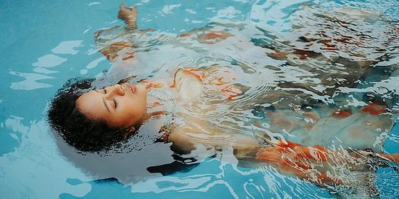 Floating Frau lässt sich im Wasser treiben