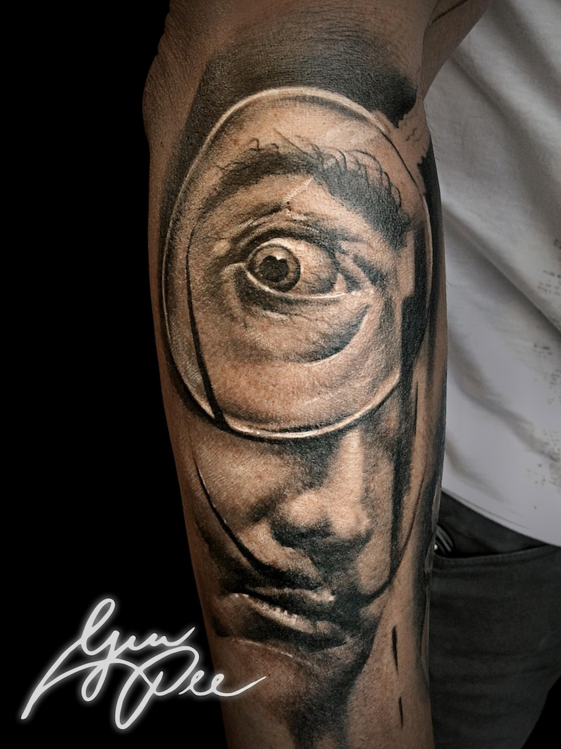 Tattoo Motiv des Künstlers Dalí mit Lupe am Unterarm