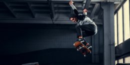 Skateboarder springt hoch auf einer Minirampe im Indoor-Skatepark