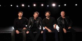 Nickelback vor schwarzem Hintergrund mit Scheinwerfern