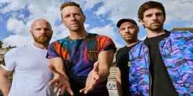 Foto der Band Coldplay, blauer Himmel im Hintergrund