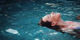 Hitze im Sommer Frau liegt im Wasser und genießt es