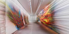 Leuchtend bunte Bilder gesprüht auf die Wände eines weißen Gangs
