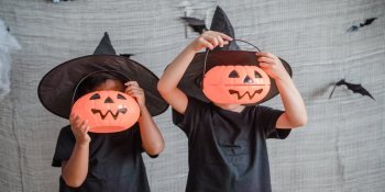 Halloween Kinder Zwei Kinder in Hexenkostümen mit Kürbislampen.