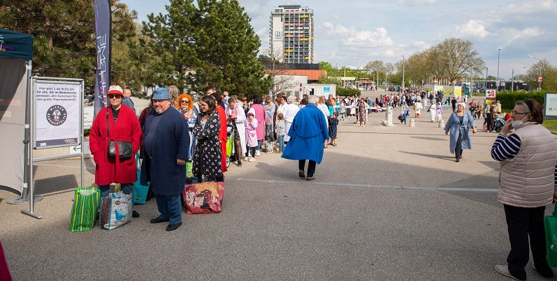 Das Bild zeigt eine Menschenschlange vor dem Eingang der Therme Wien.