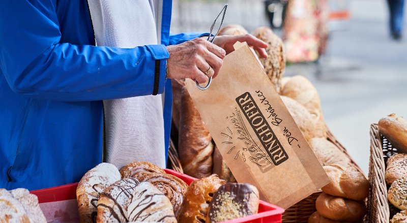 Frau packt Sackerl auf einem Straßenmarkt