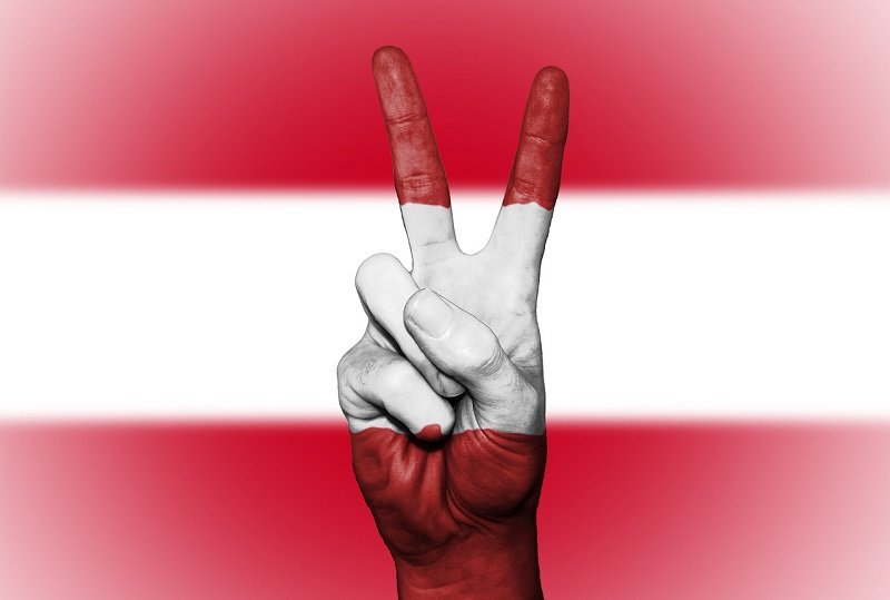 Österreichische Falgge Österreichische Flagge mit Peace-Zeichen zeigenden Fingern