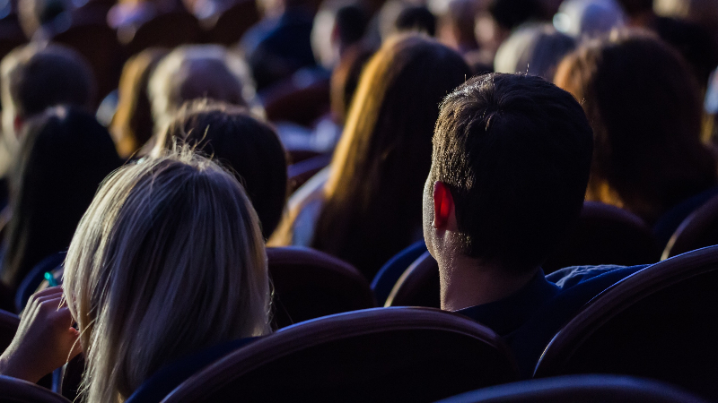 Menschen sitzen im Dunkeln und sehen sich einen Film an
